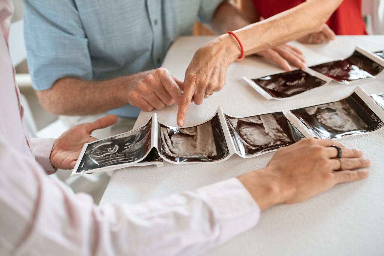about-us Family members gather around a table to discuss ultrasound photos, symbolizing love and anticipation.